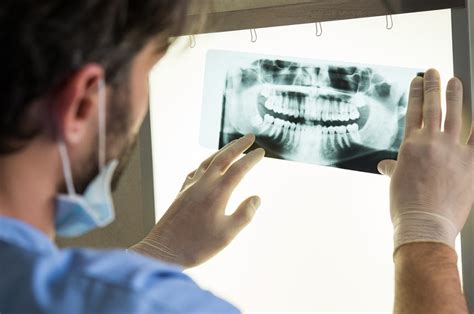 Oral surgeon examining x-ray