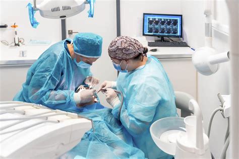 Oral surgeon using dental equipment