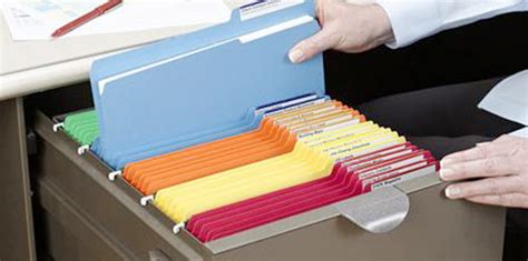 A file cabinet with hanging file folders labeled by project