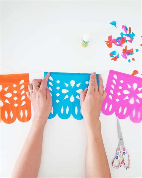 A person cutting out a papel picado design