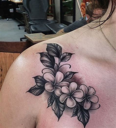 A plumeria flower tattoo on the shoulder