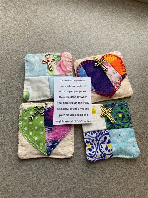 A person holding a pocket prayer quilt with a grateful expression