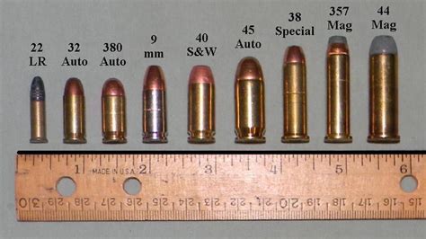 Police officer comparing pistol calibers