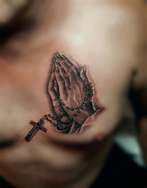 Praying hands tattoo on back