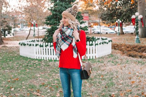 Woman wearing a red sweater with a pair of leggings and boots