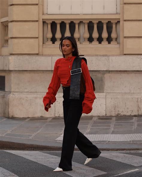 Woman wearing a red sweater with a pair of yoga pants and sneakers