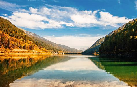 A serene landscape with a calm lake and mountains in the background