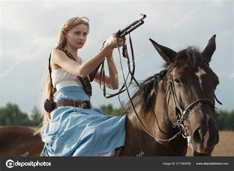 Cowboy riding horseback with shotgun