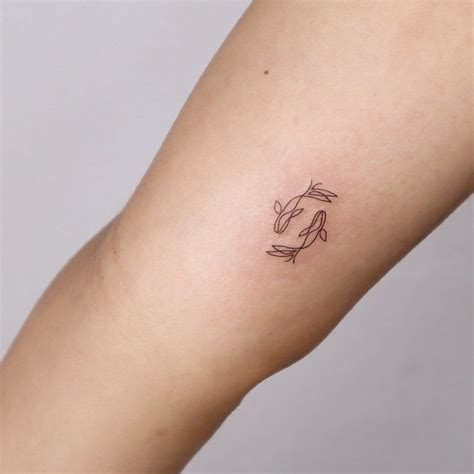 Simple koi carp tattoo featuring delicate lines and minimal color