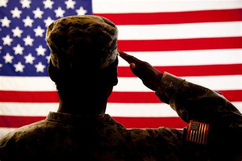 Soldiers honoring the American flag during a ceremony