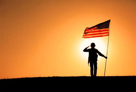 Soldiers saluting the American flag during a ceremony