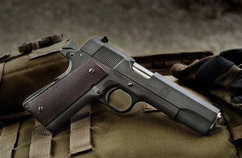 Springfield Mil Spec 1911 pistol on a wooden table with a patriotic background