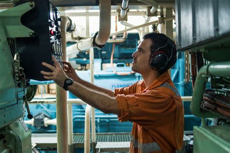 Engineer on a boat working on a machine with a sense of satisfaction