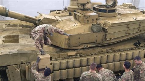 A close-up of a tank's armor plating, featuring bolts and rivets