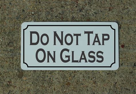 A person tapping on a glass enclosure