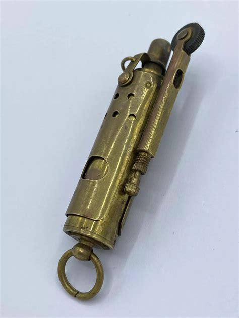 A close-up of a trench lighter's ignition system