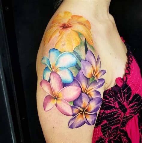 A colorful tattoo of tropical Hawaiian flowers on the sleeve