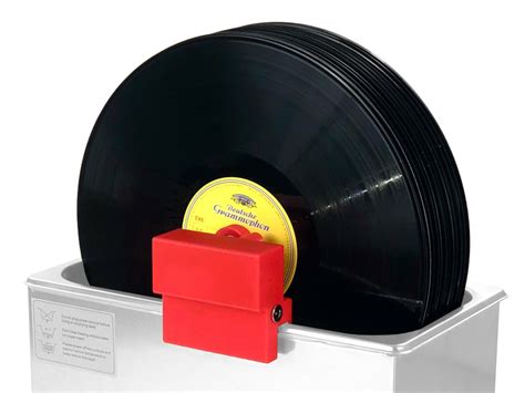 A person cleaning a vinyl record with a specialized cleaner