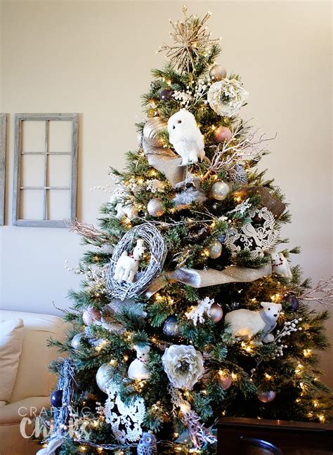 A winter wonderland-themed tree with snowflakes, pinecones, and blue ornaments